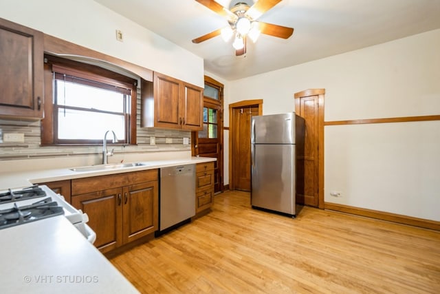 5404 W Henderson St, Chicago, IL 60641 - kitchen featuring appliances with stainless steel finishes, light wood-style flooring, tasteful backsplash, a ceiling fan, and light countertops