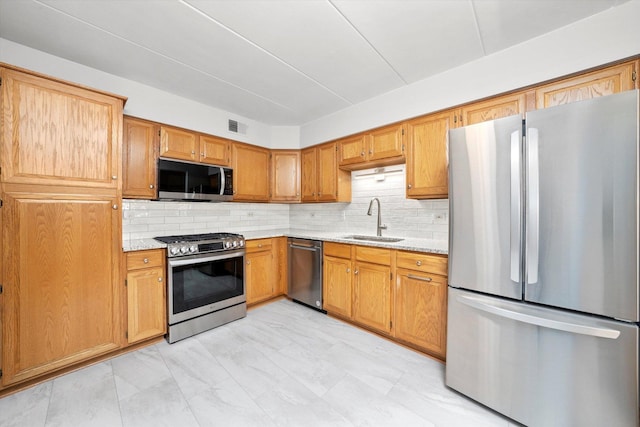 7515 Sheridan Dr Unit 1D, Willowbrook, IL 60527 - kitchen with stainless steel appliances, tasteful backsplash, light stone countertops, and brown cabinetry