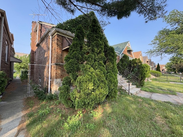 8371 S Baltimore Ave, Chicago, IL 60617 - view of property exterior featuring brick siding, a chimney, and a gate