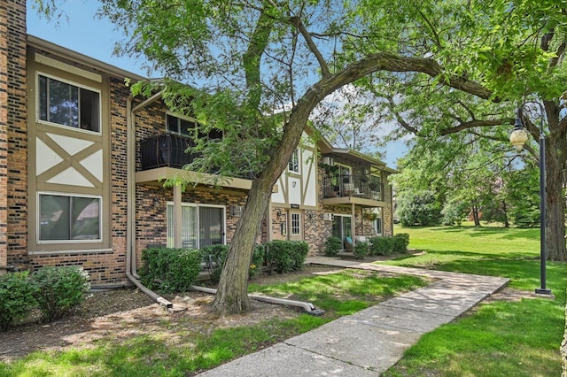 9S240 Lake Dr Unit 17-207B, Willowbrook, IL 60527 - view of front facade with a balcony, a front lawn, and brick siding
