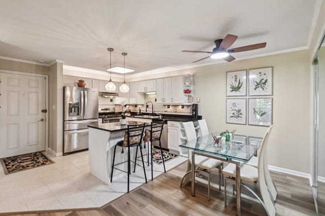9S240 Lake Dr Unit 17-207B, Willowbrook, IL 60527 - kitchen with stainless steel appliances, dark countertops, a kitchen bar, a ceiling fan, and a center island