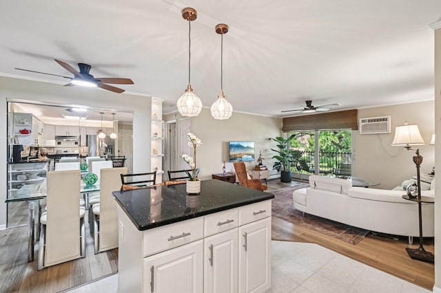 9S240 Lake Dr Unit 17-207B, Willowbrook, IL 60527 - kitchen with ceiling fan, a center island, open floor plan, white cabinetry, and an AC wall unit