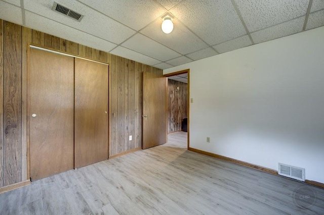 24460 Easy St, Plainfield, IL 60586 - unfurnished bedroom with a drop ceiling, wooden walls, wood finished floors, and a closet