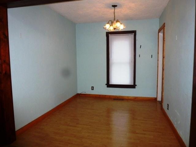 503 N Linden St, Clinton, IL 61727 - spare room featuring wood finished floors and a chandelier