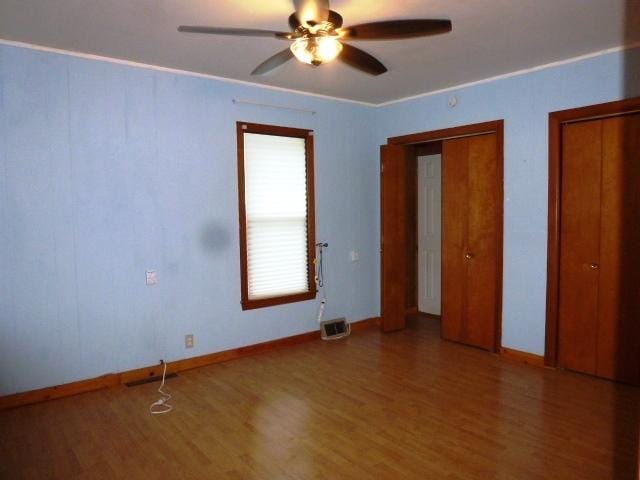 503 N Linden St, Clinton, IL 61727 - unfurnished bedroom featuring wood finished floors, multiple closets, and a ceiling fan
