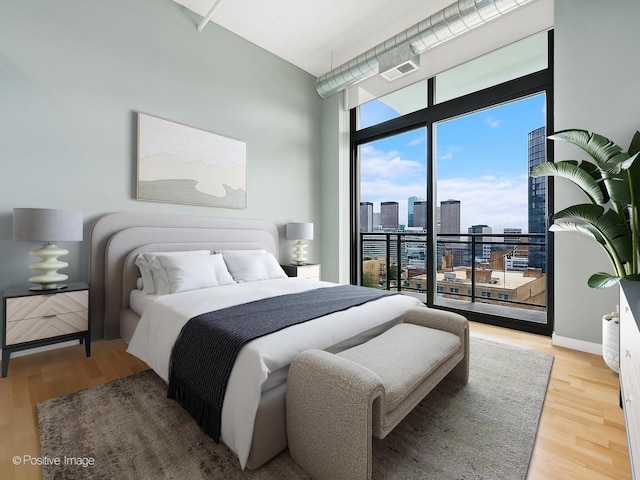 740 W Fulton St Unit 1202, Chicago, IL 60661 - bedroom featuring a skyline view, a wall of windows, access to exterior, wood finished floors, and a high ceiling