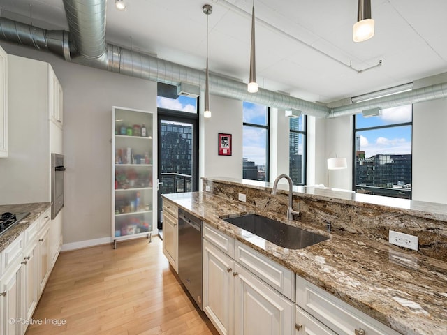 740 W Fulton St Unit 1202, Chicago, IL 60661 - kitchen with stainless steel dishwasher, light wood finished floors, hanging light fixtures, light stone counters, and white cabinets