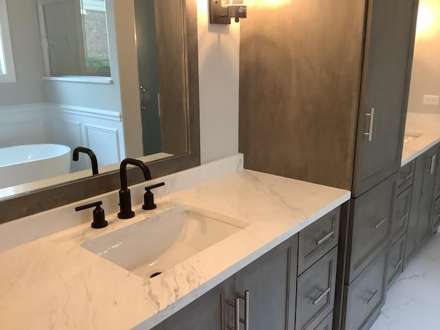 12415 Foxborough Dr, Mokena, IL 60448 - full bath featuring vanity, a decorative wall, marble finish flooring, a freestanding tub, and a wainscoted wall