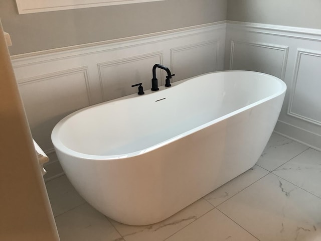 12415 Foxborough Dr, Mokena, IL 60448 - full bathroom featuring marble finish flooring, a decorative wall, a freestanding tub, and a wainscoted wall