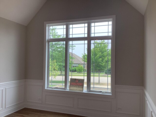 12415 Foxborough Dr, Mokena, IL 60448 - unfurnished room featuring lofted ceiling, healthy amount of natural light, wood finished floors, wainscoting, and a decorative wall