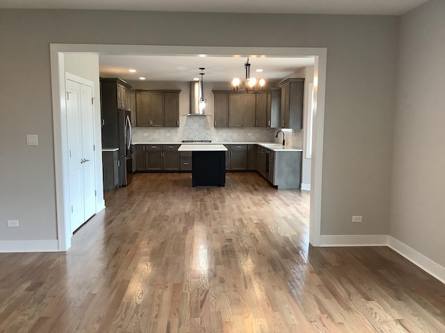 12415 Foxborough Dr, Mokena, IL 60448 - kitchen with freestanding refrigerator, wall chimney exhaust hood, light countertops, a center island, and a chandelier