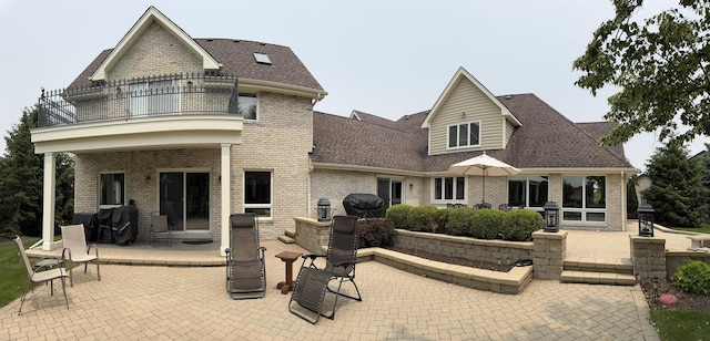10652 Lexington Ct, Frankfort, IL 60423 - rear view of house with a balcony, a patio area, brick siding, and a shingled roof