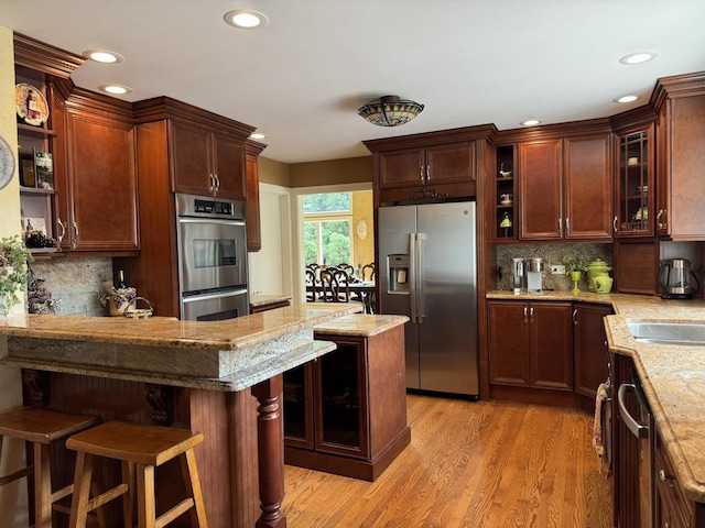 10652 Lexington Ct, Frankfort, IL 60423 - kitchen with appliances with stainless steel finishes, open shelves, glass insert cabinets, light wood-style floors, and a peninsula