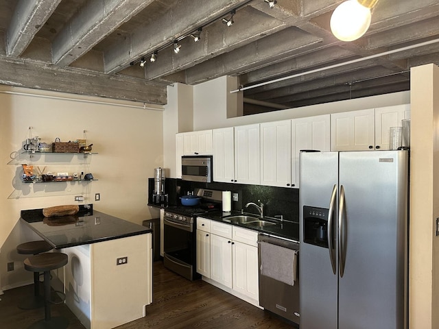 811 S Lytle St Unit 108, Chicago, IL 60607 - kitchen featuring appliances with stainless steel finishes, dark countertops, white cabinetry, and track lighting