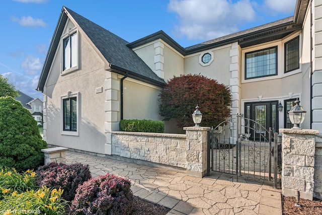 24650 Lincolnway St, Plainfield, IL 60544 - view of front of house with stucco siding, a fenced front yard, a gate, and a shingled roof