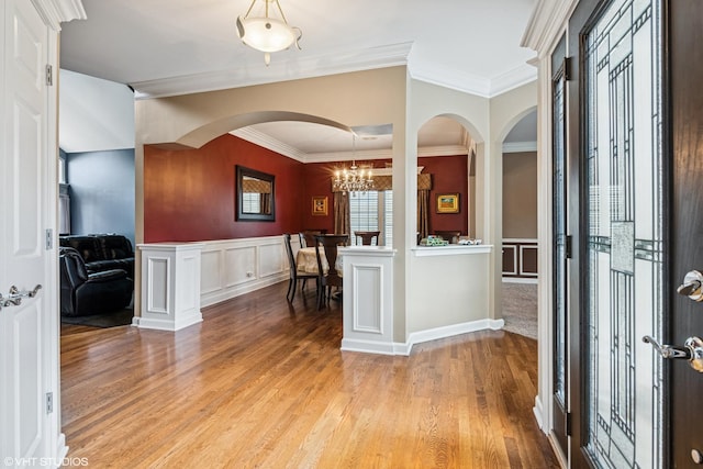24650 Lincolnway St, Plainfield, IL 60544 - entryway with light wood-style flooring, ornamental molding, a chandelier, arched walkways, and a wainscoted wall