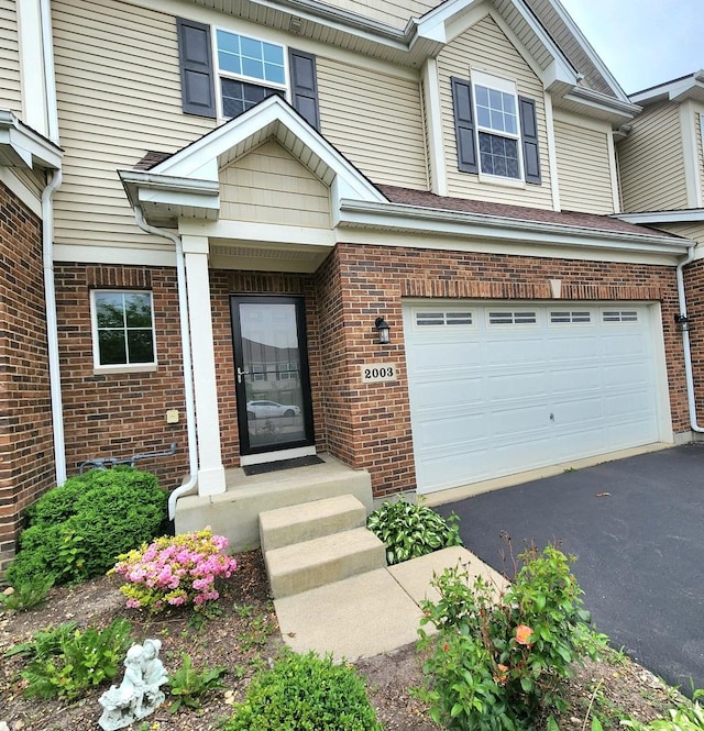 2003 Magenta Ln, Algonquin, IL 60102 - property entrance featuring an attached garage, brick siding, and driveway