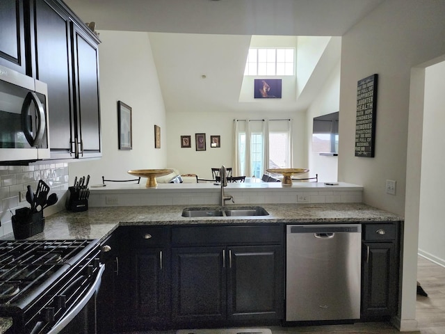 2003 Magenta Ln, Algonquin, IL 60102 - kitchen featuring stainless steel appliances, a peninsula, decorative backsplash, high vaulted ceiling, and dark cabinetry