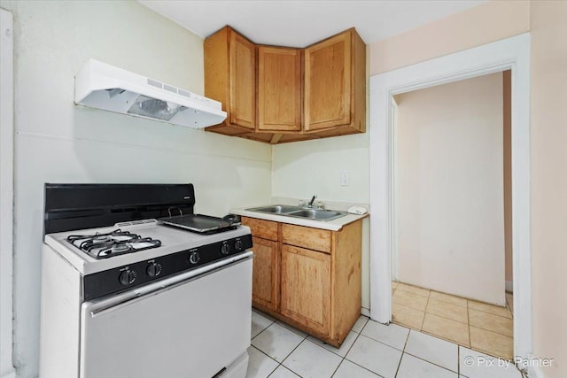 566 Raymond St, Elgin, IL 60120 - kitchen with white gas range oven, ventilation hood, light countertops, brown cabinets, and light tile patterned flooring