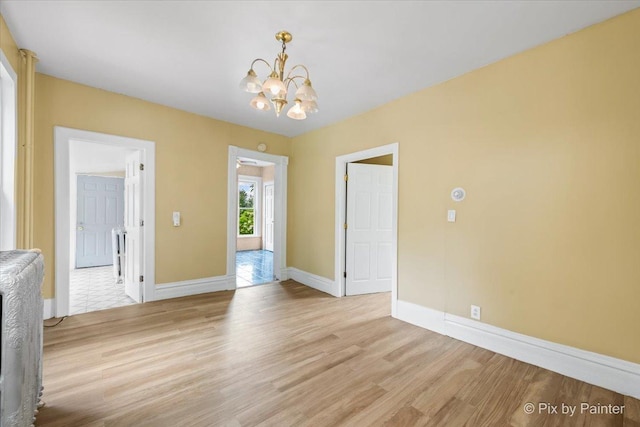 566 Raymond St, Elgin, IL 60120 - unfurnished dining area featuring a chandelier and light wood-style flooring