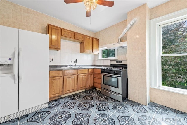 566 Raymond St, Elgin, IL 60120 - kitchen featuring white fridge with ice dispenser, stainless steel range with gas cooktop, healthy amount of natural light, and ceiling fan