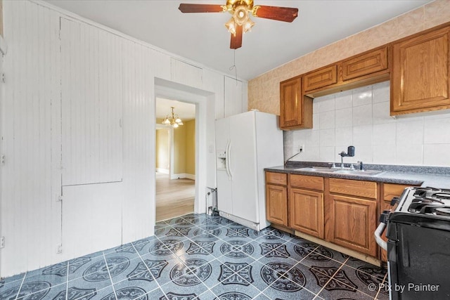 566 Raymond St, Elgin, IL 60120 - kitchen with white refrigerator with ice dispenser, gas range, brown cabinetry, and ceiling fan