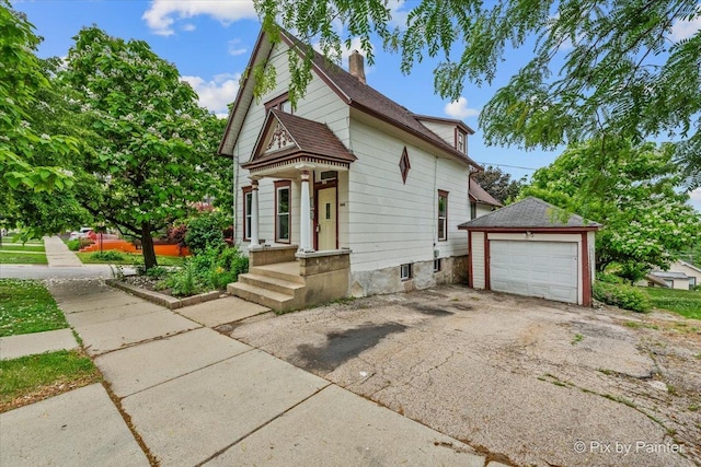 566 Raymond St, Elgin, IL 60120 - victorian-style house featuring asphalt driveway, a garage, a chimney, and an outbuilding