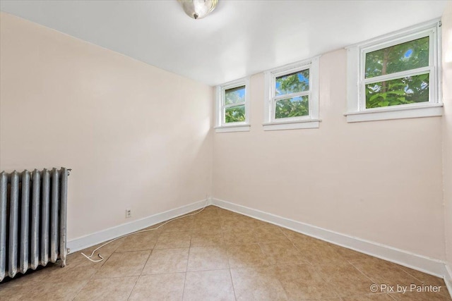 566 Raymond St, Elgin, IL 60120 - empty room featuring radiator heating unit and light tile patterned flooring
