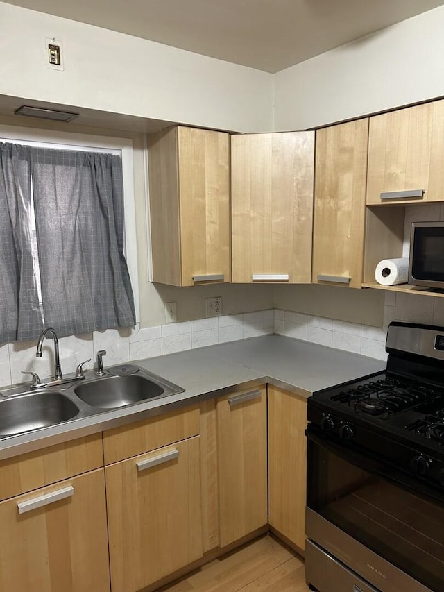 214 S Oak Park Ave Unit 2, Oak Park, IL 60302 - kitchen with gas range oven, light brown cabinetry, backsplash, and light wood-style floors