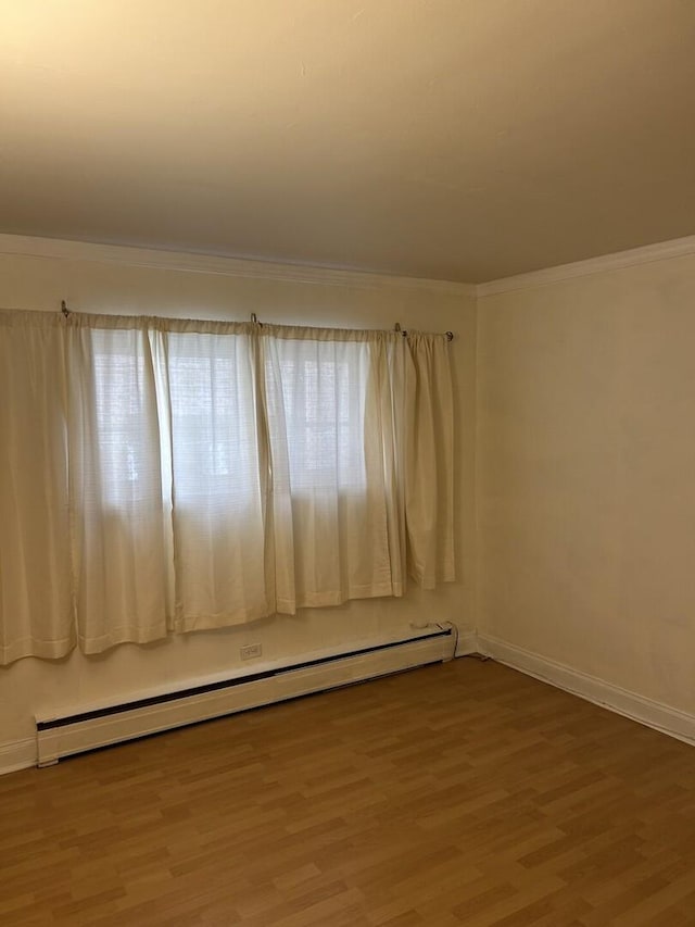 214 S Oak Park Ave Unit 2, Oak Park, IL 60302 - empty room featuring baseboard heating, ornamental molding, and wood finished floors