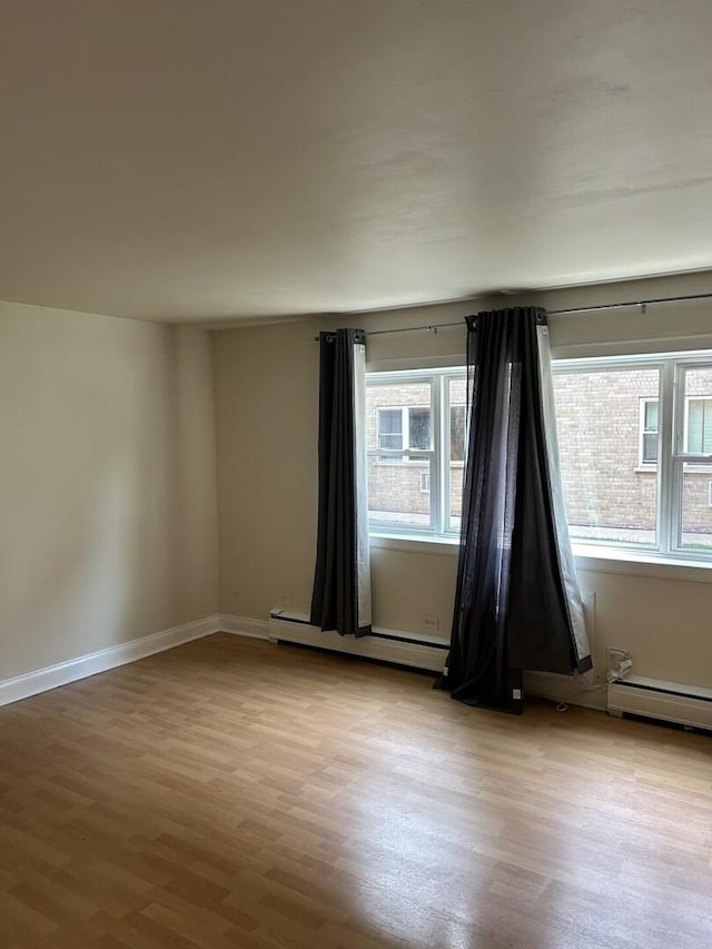 214 S Oak Park Ave Unit 2, Oak Park, IL 60302 - unfurnished room featuring wood finished floors and a baseboard heating unit