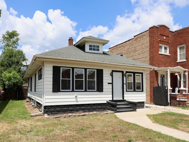 507 Grant Ave, Joliet, IL 60433 - bungalow featuring a chimney, a front yard, and roof with shingles