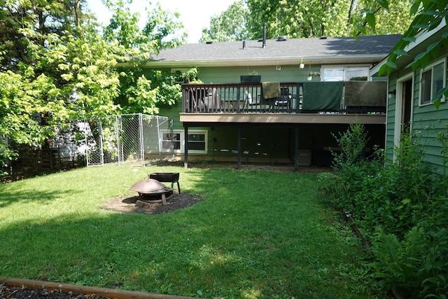 505 Woodmoor Dr, Round Lake Beach, IL 60073 - rear view of house featuring an outdoor fire pit, a deck, a lawn, and roof with shingles