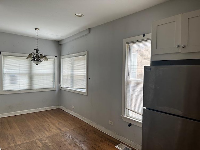 4131 N Monticello Ave, Chicago, IL 60618 - unfurnished dining area featuring a chandelier and dark wood-style floors