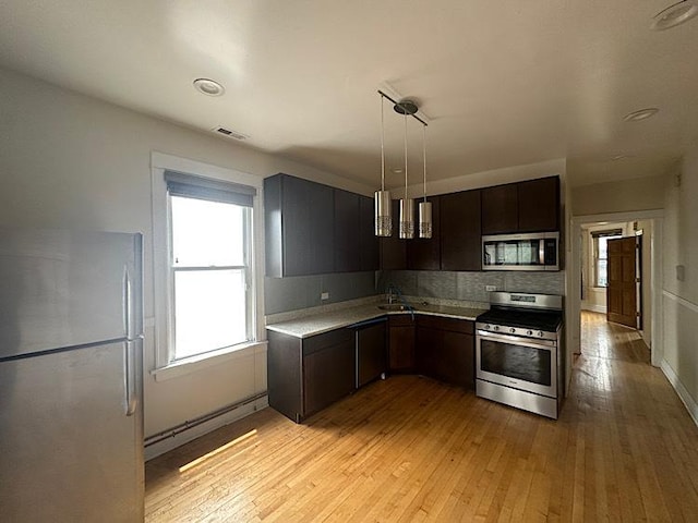 4131 N Monticello Ave, Chicago, IL 60618 - kitchen with appliances with stainless steel finishes, light countertops, light wood-style flooring, and dark brown cabinets