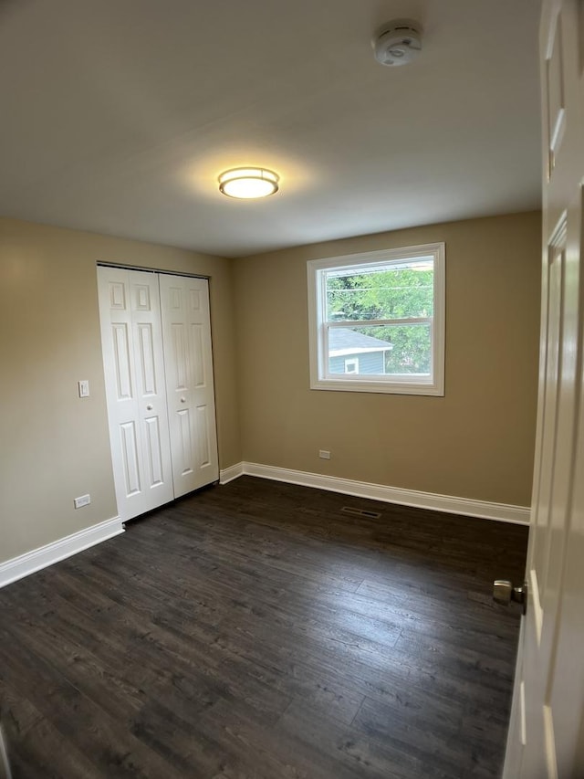 805 Monroe Ave, Carpentersville, IL 60110 - unfurnished bedroom featuring dark wood finished floors and a closet