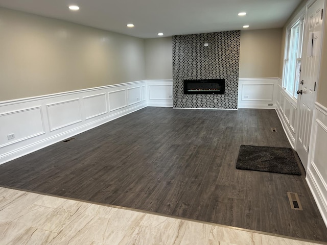 805 Monroe Ave, Carpentersville, IL 60110 - unfurnished living room featuring a decorative wall, a fireplace, dark wood-style flooring, recessed lighting, and wainscoting