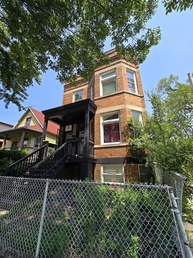 view of front of home with brick siding and stairway