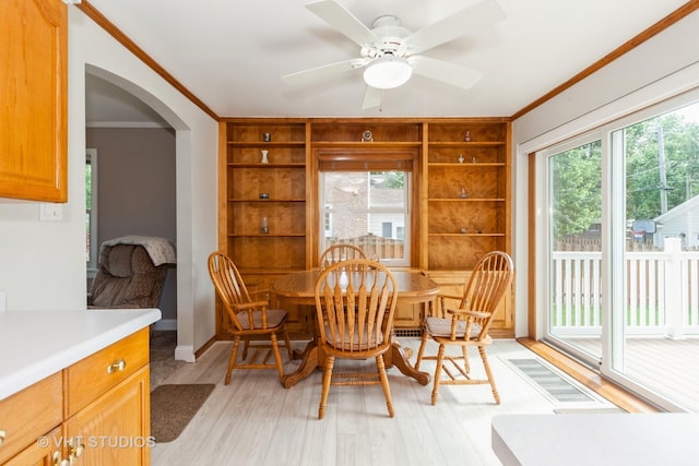 636 S 10th Ave, La Grange, IL 60525 - dining room featuring crown molding, light wood-style floors, built in shelves, arched walkways, and ceiling fan