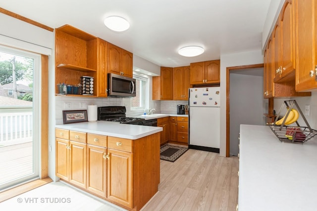 636 S 10th Ave, La Grange, IL 60525 - kitchen featuring freestanding refrigerator, stainless steel microwave, range with gas cooktop, a peninsula, and light wood-style floors