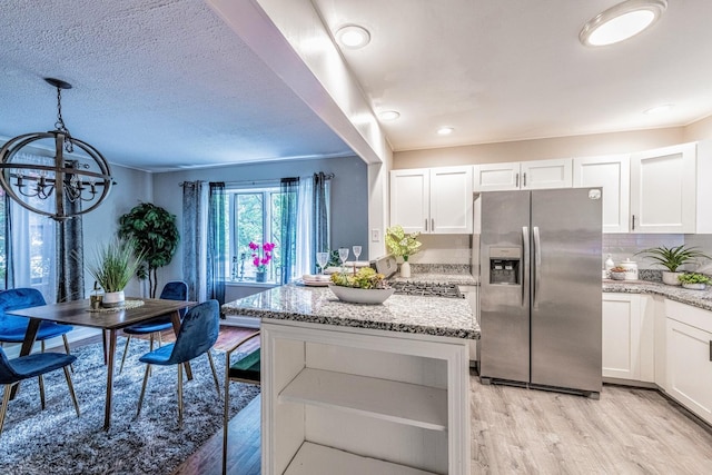 1502 N 34th Ave, Melrose Park, IL 60160 - kitchen featuring stainless steel fridge, light wood-style flooring, a chandelier, light stone counters, and white cabinetry
