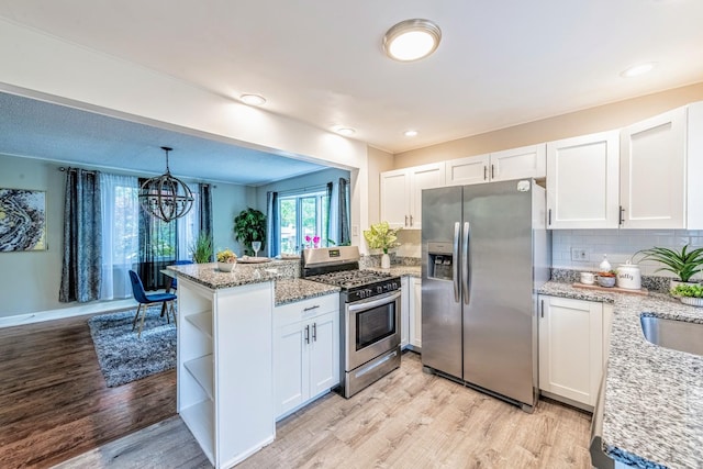 1502 N 34th Ave, Melrose Park, IL 60160 - kitchen with stainless steel appliances, a peninsula, white cabinets, open shelves, and light wood-type flooring