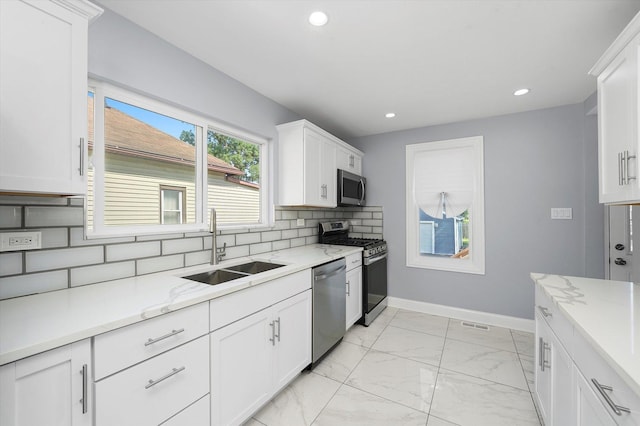 536 E 155th St, Phoenix, IL 60426 - kitchen with stainless steel appliances, backsplash, recessed lighting, light marble finish floors, and white cabinetry
