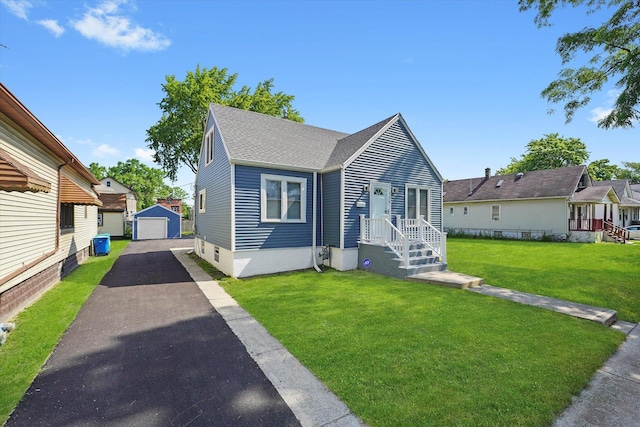 536 E 155th St, Phoenix, IL 60426 - view of front of property featuring driveway, a detached garage, an outdoor structure, a front lawn, and a shingled roof