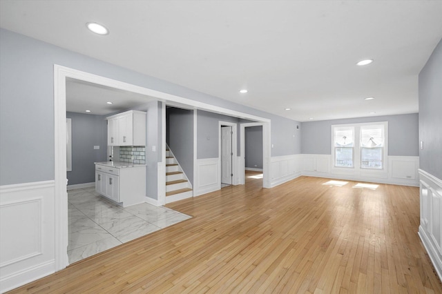 536 E 155th St, Phoenix, IL 60426 - unfurnished living room with wainscoting, stairway, light wood-style flooring, a decorative wall, and recessed lighting