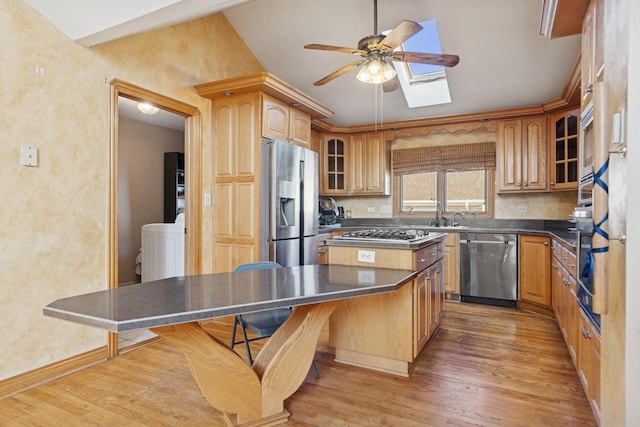 7505 Blazer Ave, Justice, IL 60458 - kitchen with appliances with stainless steel finishes, ceiling fan, light wood finished floors, a kitchen island, and glass insert cabinets