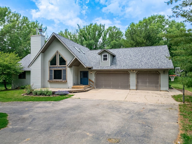 4293 W Rockton Rd, Rockton, IL 61072 - view of front of house featuring roof with shingles, concrete driveway, an attached garage, and a chimney