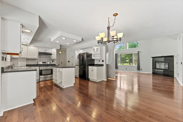 4293 W Rockton Rd, Rockton, IL 61072 - kitchen featuring stainless steel range with gas stovetop, freestanding refrigerator, dark countertops, a chandelier, and white cabinetry