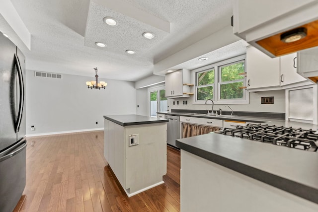 4293 W Rockton Rd, Rockton, IL 61072 - kitchen featuring a textured ceiling, appliances with stainless steel finishes, dark countertops, a chandelier, and a center island
