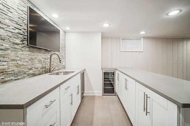630 Wesley Dr, Park Ridge, IL 60068 - kitchen featuring wine cooler, a peninsula, tasteful backsplash, white cabinetry, and wood walls